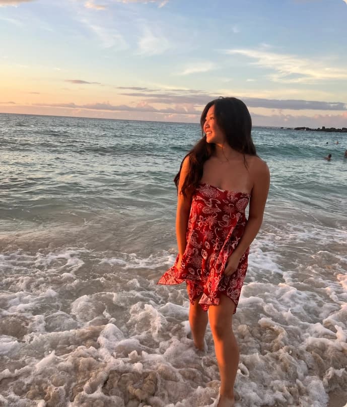 Marisa smiling on the beach at sunset.